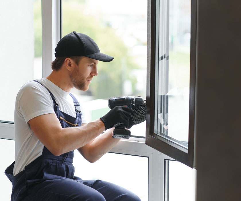 Technicien qui installe une fenêtre en aluminium